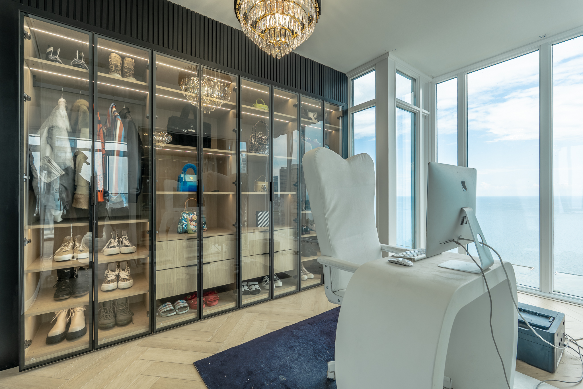 Custom glass-front closet with integrated lighting