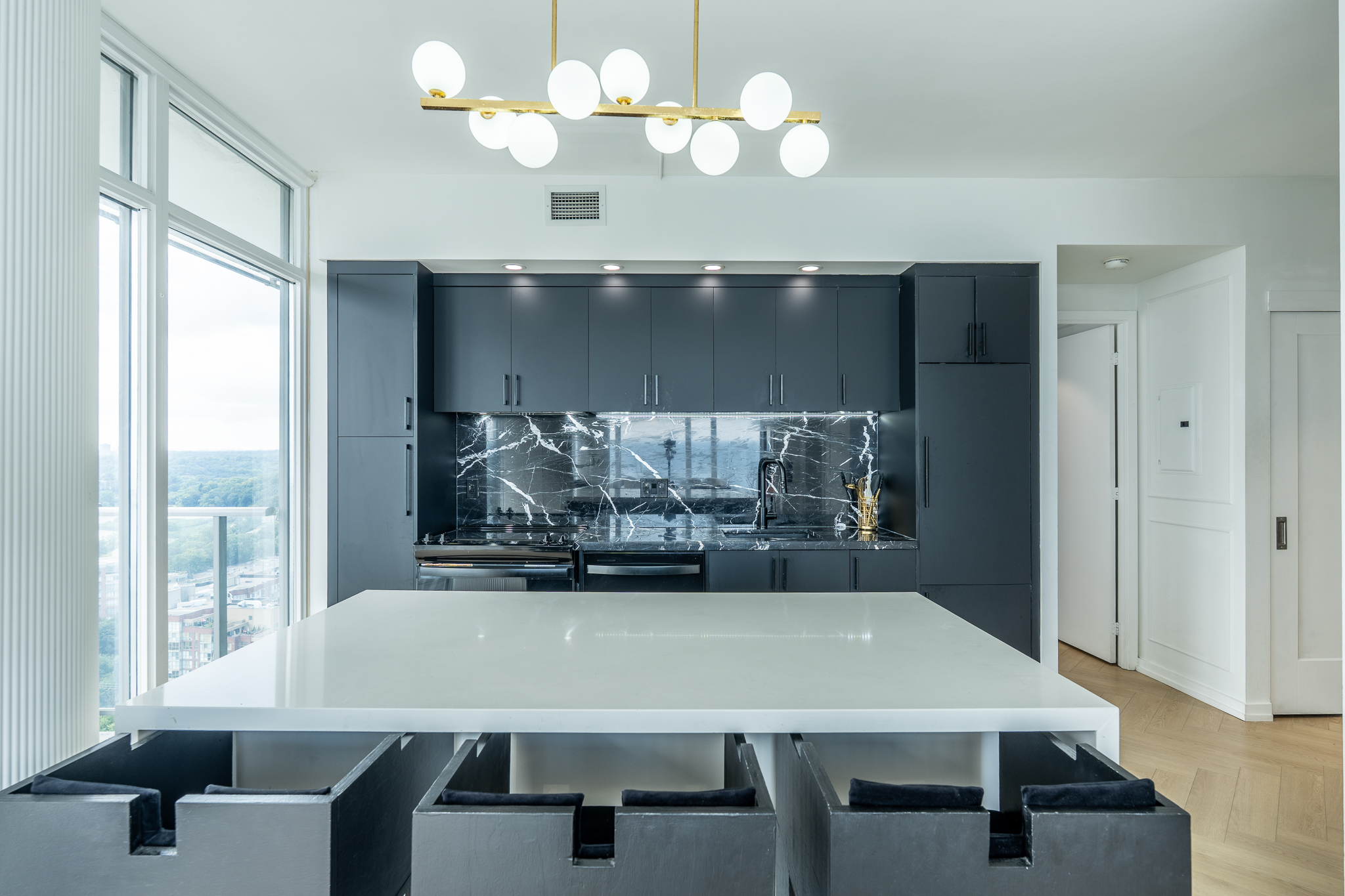 Chef-inspired kitchen with quartz waterfall island, custom cabinetry and marble backsplash